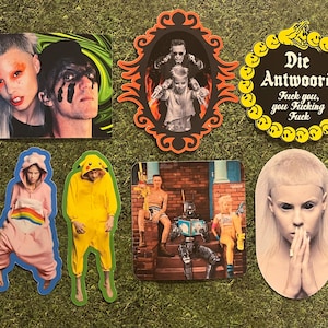 Könnte beinhalten: Eine Sammlung von Aufklebern mit verschiedenen Bildern. Ein Aufkleber zeigt ein Paar mit Make-up, ein anderer ein gerahmtes Foto und ein dritter mit dem Text "Die Antwoord Fuck you, you Fucking Fuck". Weitere Aufkleber zeigen Figuren in Kostümen.
