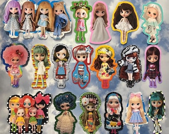 May include: A collection of colorful doll stickers with various hairstyles and outfits. The dolls are cut out with decorative borders and are set against a cloudy sky background. The dolls' outfits include dresses, coats, and patterned clothing.