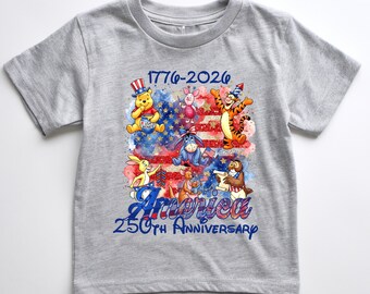 Puede incluir: Una camiseta gris jaspeado de manga corta con un gráfico de los personajes de Winnie the Pooh sobre una bandera estadounidense en acuarela. El texto dice 1776-2026 America 250th Anniversary. El diseño incluye a Pooh, Piglet, Tigger, Eeyore y otros.