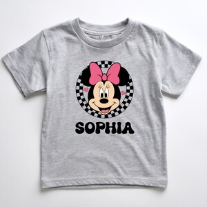 A gray t-shirt with a Minnie Mouse graphic and the name "Sophia" printed below it.