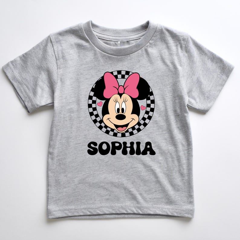 A gray t-shirt with a Minnie Mouse graphic and the name "Sophia" printed below it.