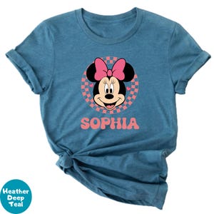 A blue t-shirt with a Minnie Mouse graphic and the name "Sophia" printed on it.