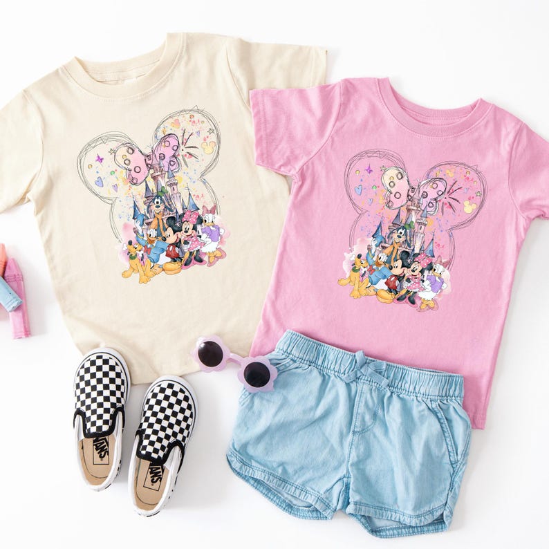 A casual outfit consisting of a pink t-shirt with a cartoon butterfly design, denim shorts, black and white checkered shoes, and sunglasses.