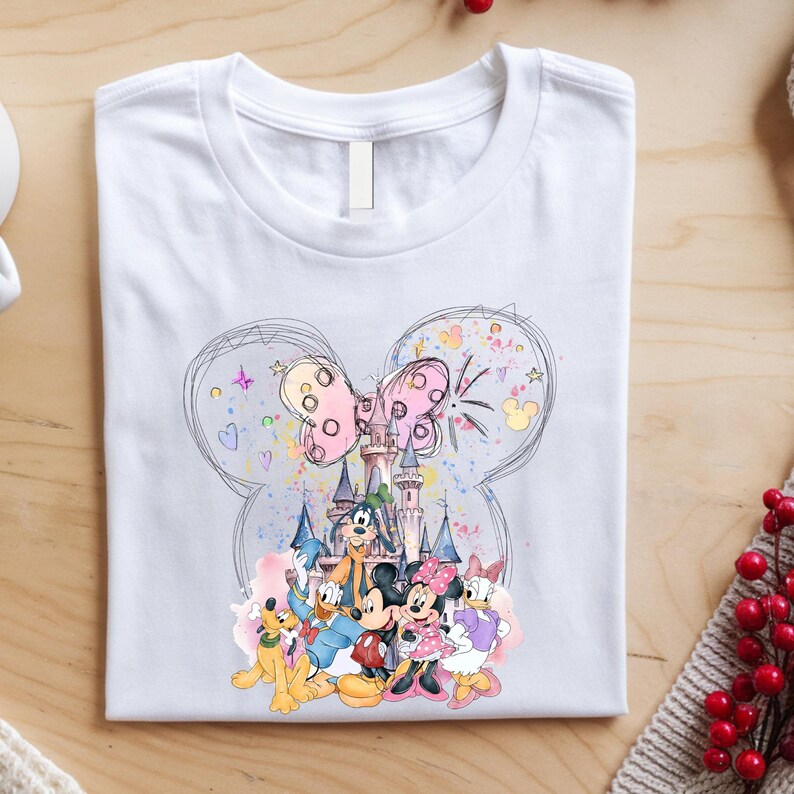 A white t-shirt with a colorful graphic design featuring Disney characters such as Mickey Mouse, Minnie Mouse, Donald Duck, Goofy, and Pluto.