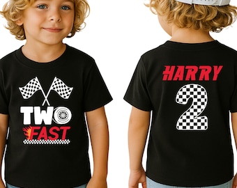 May include: A black t-shirt featuring a racing theme with two checkered flags, a tire, and the text TWO FAST in white and red. The back of the shirt displays the name HARRY in red above a large checkered number 2. The shirt has short sleeves.
