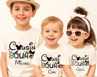 May include: Three off-white t-shirts featuring the text Cousin Squad in black, with character-themed letters and small star accents. Each shirt displays a unique name: Michael, Carl, or Grace. The designs incorporate iconic mouse and duck silhouettes.