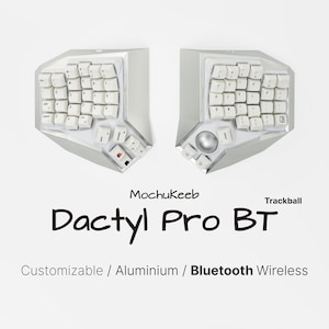 May include: A split ergonomic keyboard with white keys and a silver aluminum chassis. The device features a trackball on the right half and includes the text Mochukeeb Dactyl Pro BT Customizable / Aluminium / Bluetooth Wireless on the display.