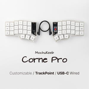 Peut inclure: Un clavier ergonomique séparé avec des touches blanches, un câble de connexion noir et un bouton TrackPoint rouge. Le texte indique MochuKeeb Corne Pro Customizable / TrackPoint / USB-C Wired. L'appareil possède un cadre blanc et des circuits.