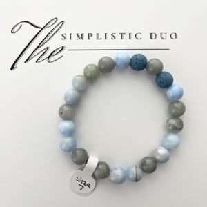 May include: A bracelet made of round beads in shades of blue, grey, and dark blue. The bracelet has a size 7 tag. The text "The Simplistic Duo" is above the bracelet.
