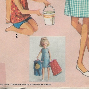 Könnte beinhalten: Eine Puppe mit blonden Haaren, die ein blau-weiß kariertes Kleid trägt, hält zwei Outfits in der Hand: ein blau-gelbes Outfit und ein rot-weißes Outfit. Die Puppe steht auf einem weißen Hintergrund.