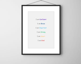 May include: A framed print with a white background and black frame. The text "I am Confident, Brave, Important, Strong, Smart, Kind" is displayed in a rainbow of colors. The print is hanging on a white wall.