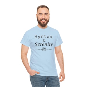 Peut inclure: Un t-shirt bleu clair avec l'inscription "Syntax & Serenity" en noir, accompagnée d'un motif de fleur de lotus. Le t-shirt est porté par une personne.