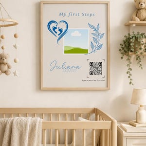 Peut inclure: Une affiche encadrée avec le texte My first Steps, le prénom Juliana et la date 13082025. Le design comprend un cœur bleu avec des empreintes de pieds de bébé, un emplacement photo carré, une branche de feuilles bleue et un QR code avec le texte Scan to watch my first steps.