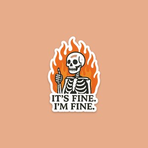 May include: A sticker featuring a cartoon skeleton giving a thumbs up, surrounded by orange flames. The text "IT'S FINE. I'M FINE." is below the skeleton. The sticker is on a peach-colored background.