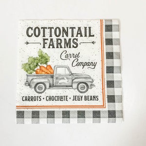 May include: A white napkin with a black and white checkered border. The napkin features a vintage truck with a bunny logo, carrying carrots. The text reads "Cottontail Farms Carrot Company Carrots Chocolate Jelly Beans".