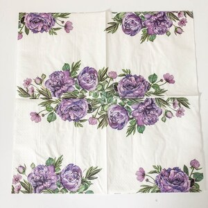 Puede incluir: Servilletas de papel blancas con un dise&ntilde;o floral morado. El dise&ntilde;o presenta un borde de flores y hojas moradas alrededor de los bordes de la servilleta. El centro de la servilleta presenta un dise&ntilde;o floral m&aacute;s grande con flores y hojas moradas.