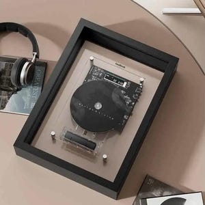 May include: A black framed display featuring a black CD and circuit board design. The CD is mounted on a clear acrylic panel. The frame is rectangular and sits on a light brown surface. The text "CoolDesk" is visible.