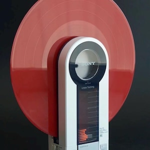 May include: A vintage Sony PS-F9 Linear Tracking turntable with a red vinyl record. The turntable is white with black and silver accents, and features the Sony logo. The record player is on a wooden base.