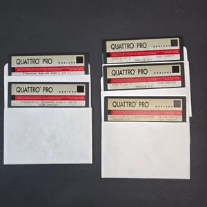 Puede incluir: Un conjunto de cinco disquetes negros de 3,5 pulgadas para el software Quattro Pro de Borland, cada uno en una funda de papel blanco. Las etiquetas muestran el logotipo de Quattro Pro, la versión 4.0 y designaciones como Installation y Financial Analyst.