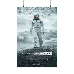 May include: A movie poster for Interstellar featuring an astronaut in a white suit standing on a rocky, snowy landscape. The text reads The end of earth will not be the end of us, Interstellar, and release dates in November.