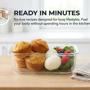 May include: A rectangular glass food storage container filled with three golden-brown muffins, two peeled hard-boiled eggs, fresh spinach leaves, raspberries, and blueberries. Text reads: READY IN MINUTES. No-fuss recipes designed for busy lifestyles.