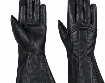 Op de afbeelding: Een paar zwarte leren handschoenen met een uitlopend manchetontwerp en verticale gestikte panelen. De handschoenen hebben een gladde afwerking, een duimstuk en een opvallende gebogen naad over de rug van de hand. Eén wijsvingertop heeft een donker stoffen inzetstuk.