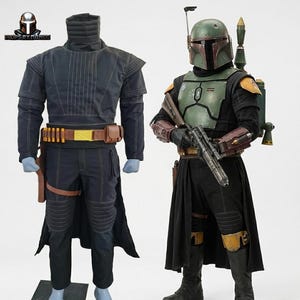 May include: Two detailed costumes, one resembling a Mandalorian warrior and the other a character from the Star Wars universe. The Mandalorian-style outfit is dark blue with a yellow belt. The other costume features a green helmet and armour, with a black outfit and a blaster.
