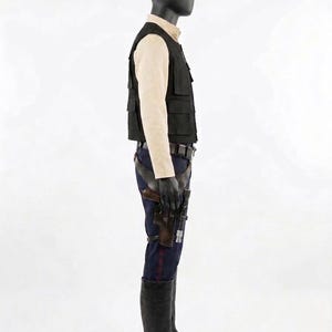 May include: A costume on a mannequin, featuring a black vest with multiple pockets, a light tan shirt, dark blue pants with a red stripe, a holster with a gun, and black boots. The outfit is displayed on a black mannequin.