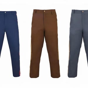 May include: Three pairs of trousers in navy blue, brown, and grey. Each pair has a straight leg and a decorative stripe down the side. The navy pair has a pink stripe, while the brown and grey pairs have a gold stripe.
