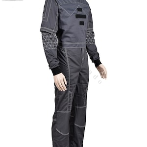 Puede incluir: Mono gris con costuras blancas y detalles negros. La parte superior de manga larga tiene un cuello alto y patrones geom&eacute;tricos en las mangas. Los pantalones tienen parches reforzados en las rodillas. Ideal para cosplay o disfraces.