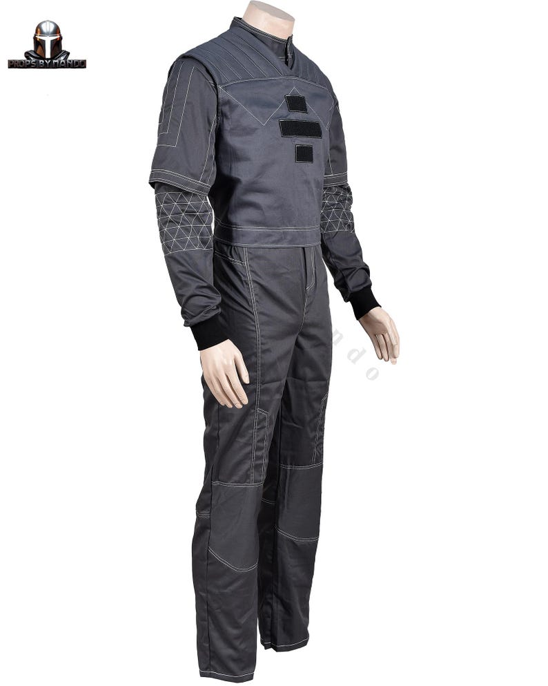 Puede incluir: Mono gris con costuras blancas y detalles negros. La parte superior de manga larga tiene un cuello alto y patrones geom&eacute;tricos en las mangas. Los pantalones tienen parches reforzados en las rodillas. Ideal para cosplay o disfraces.