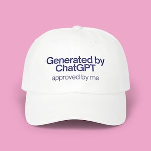 Op de afbeelding: Een witte baseballcap met een gebogen klep. De cap heeft de tekst "Generated by ChatGPT" boven "approved by me" in marineblauw. De hoed staat tegen een roze achtergrond.
