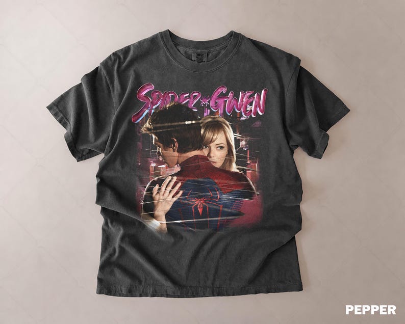 May include: Dark grey t-shirt with a graphic of Spider-Man and Gwen Stacy embracing, and the text "Spider & Gwen" in pink and blue. The shirt has a vintage, distressed appearance.