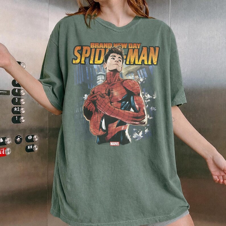 Pu&ograve; includere: T-shirt verde con grafica di Spider-Man e la scritta "BRAND NEW DAY SPIDER-MAN" in giallo e arancione. Il logo Marvel &egrave; in basso. La maglietta ha una vestibilit&agrave; ampia.