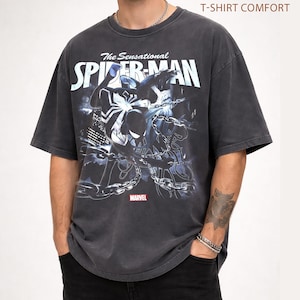 May include: Dark gray t-shirt featuring a graphic of Spider-Man with the text "The Sensational Spider-Man" and the Marvel logo. The shirt has a vintage, distressed look.