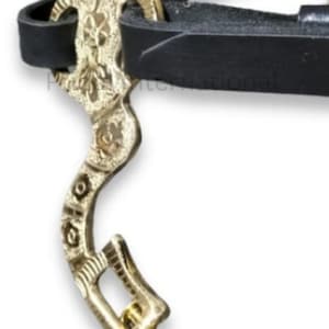 May include: Close-up of a gold-colored horse bit with intricate floral and scrollwork designs. The bit is connected to a black leather strap. The metal has a shiny finish, and the overall design is ornate.