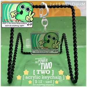 May include: A clear acrylic keychain featuring a green cartoon character with the text "TPOT 1: You know those buttons don't do anything, right?" and "THE POWER OF TWO". The charm measures 2 x 1.5 inches.