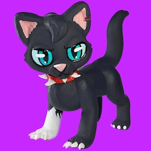 May include: A black cat figurine with striking teal eyes and a red spiked collar. The cat has a white-tipped paw and ears with pink accents. The figurine is set against a vibrant purple background.