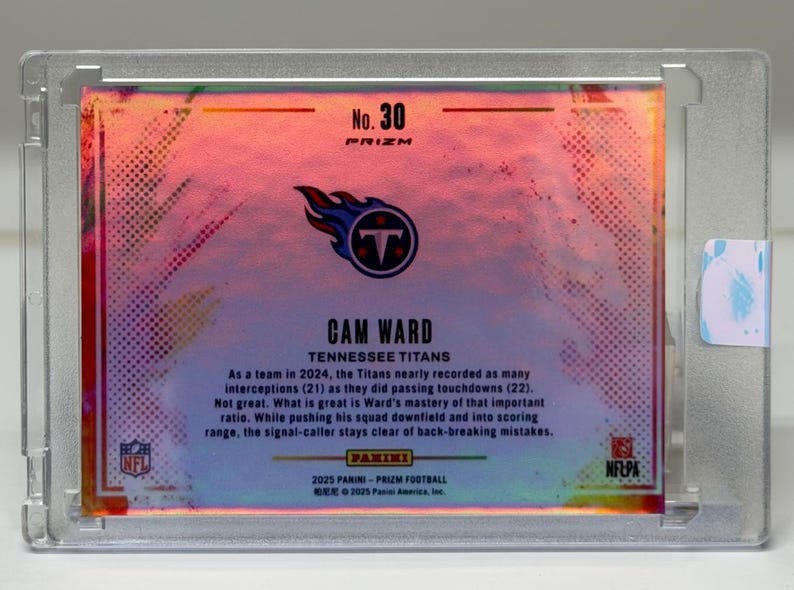 May include: A Cam Ward Tennessee Titans football card, encased in a clear protective holder. The card features the team logo and player information, with the text "No. 30 PRIZM". The background has a colorful, iridescent design.