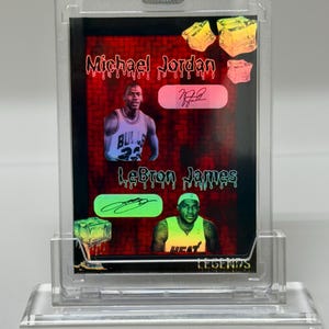Peut inclure: Carte de collection de basket-ball avec Michael Jordan et LeBron James. La carte présente un fond dégradé rouge et noir avec les images et les signatures des joueurs. La carte est enfermée dans un support en plastique transparent.