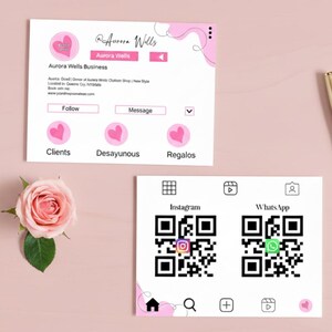 May include: Two business cards with pink accents and text. One card features the name "Aurora Wells" and social media icons. The other card has a QR code for Instagram and WhatsApp. A pink rose is in the lower left corner.