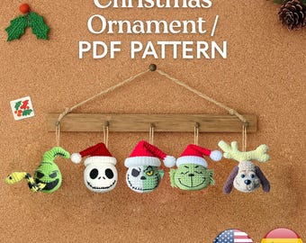 May include: A wooden display with five crocheted Christmas ornaments. The ornaments include a green snake, a Jack Skellington head, two Grinch heads, and a dog head with antlers. The text "Christmas Ornament / PDF PATTERN" is at the top.