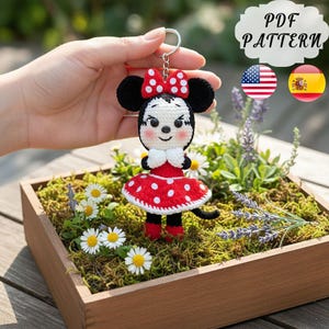 May include: A handmade crochet Minnie Mouse keychain. The keychain features a red dress with white polka dots, a matching bow, and black ears. The text "PDF PATTERN" is visible in the image.
