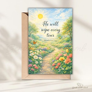 May include: A greeting card with a scenic landscape illustration. The image features a sunny sky, a path through a flower-filled meadow, and the text "He will wipe every tear, Revelation 21:4". The card is inside a brown envelope.