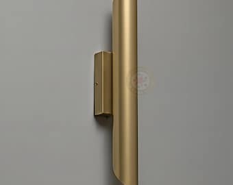 May include: A gold-colored wall sconce with a cylindrical design. The sconce has a rectangular base and a curved, elongated body. The text "Star lighting hub" is at the bottom.