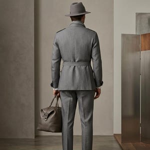 Full-length view of a men’s grey formal safari suit with waistcoat, belt detail, and fedora hat.
