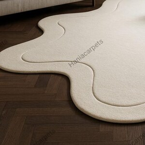Transform your space with this Solid Off White Irregular Amoeba Shape Rug, a modern hand-tufted wool area rug designed to bring style, comfort, and uniqueness to your home. Crafted with a soft high pile texture, this rug creates a cozy and inviting feel underfoot, making it perfect for living rooms, bedrooms, nurseries, or kids’ play areas. Its off-white tone blends seamlessly with any interior style, from minimalist and Scandinavian to boho and contemporary décor.