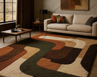 May include: A large, rectangular area rug with a retro design. The rug features a pattern of curved, abstract shapes in shades of brown, beige, and green. The rug is placed in a living room with a sofa, coffee table, and artwork.