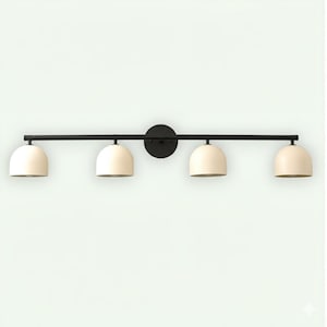 May include: A black, four-light vanity light fixture. The fixture has a horizontal bar with four off-white, dome-shaped shades. The shades are evenly spaced and attached to the bar. A circular plate is in the center of the bar.