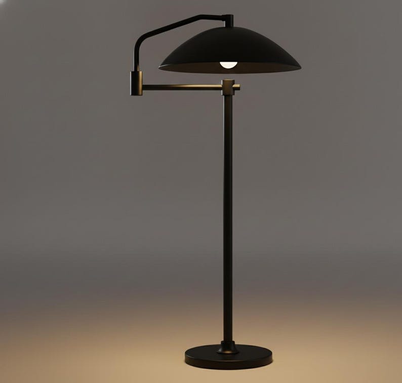 May include: A contemporary black floor lamp featuring a curved arm and a domed shade. The lamp stands on a circular base with a slender pole. The light is on, casting a glow beneath the shade.